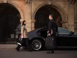Professional Mak Louren chauffeur providing premium airport car service with luxury vehicle and luggage assistance.