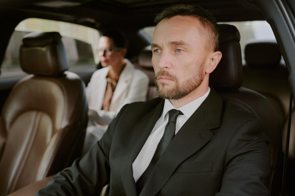 Professional chauffeur in a luxury car providing premium transportation services.