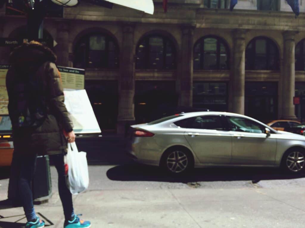 Luxury sedan parked on city street for chauffeur service.