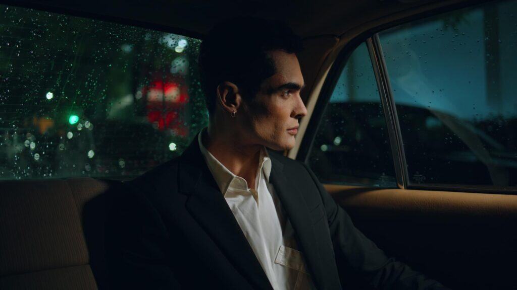 Man in formal suit sitting in luxury car for chauffeur service at night.
