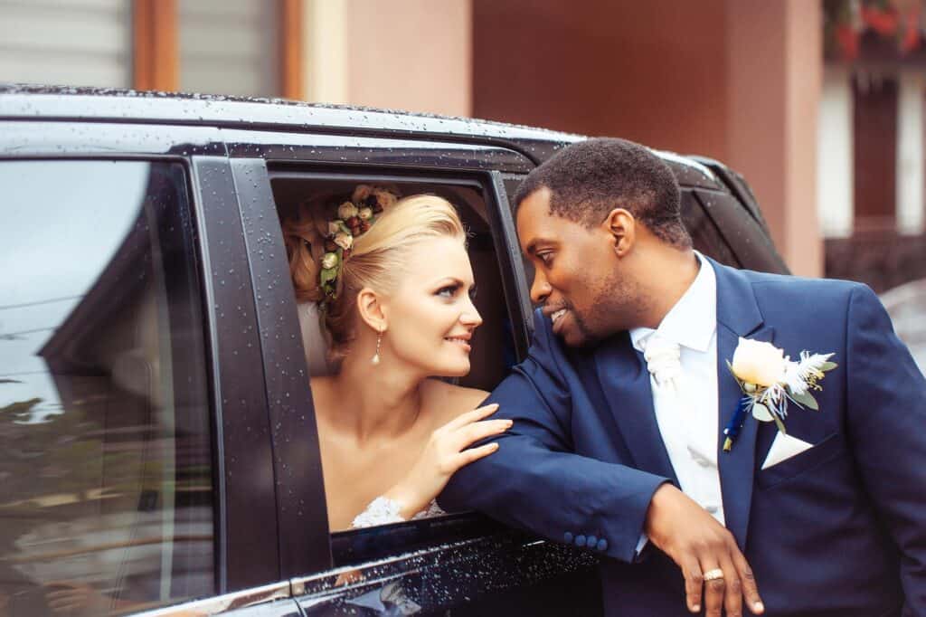 Elegant wedding couple sharing a moment inside a luxury chauffeur service vehicle.